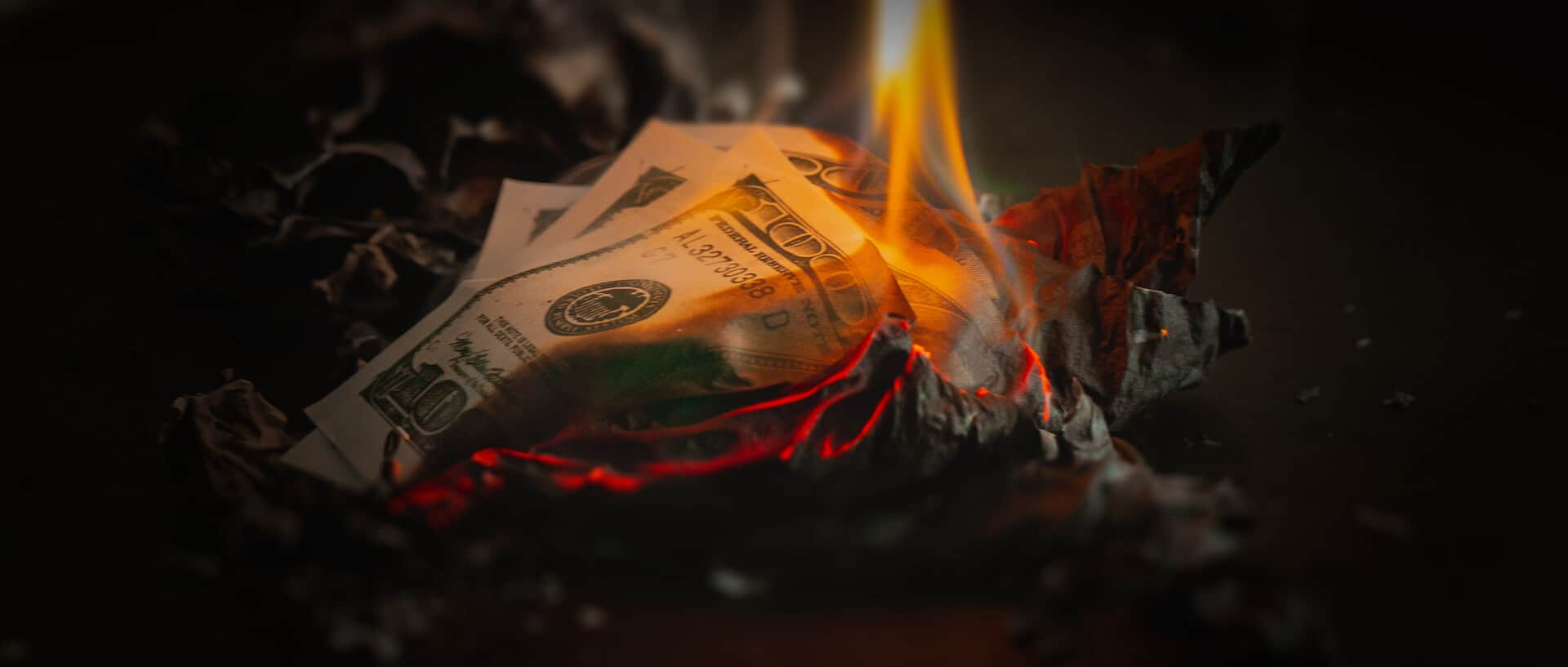 Burning hundred-dollar bills: a dramatic portrayal of wealth going up in smoke.