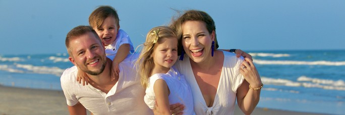 A happy family enjoying a sunny day at the beach, with smiles all around as they create cherished memories together.