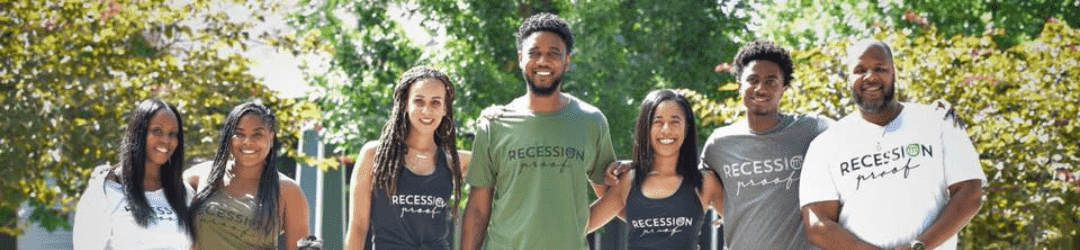 A group of smiling young adults wearing t-shirts with the word 