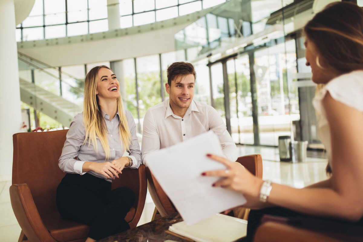 Financial advisor showing report to young couple for their investment.