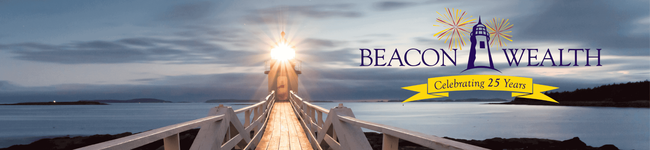 A serene evening view of a wooden bridge extending over calm waters towards a horizon illuminated by a setting or rising sun, commemorating 